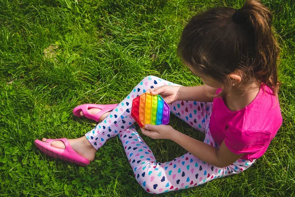 カラフルなストレス感知おもちゃフィジェットは子供の手でそれをプッシュします 選択的フォーカス — ストック写真