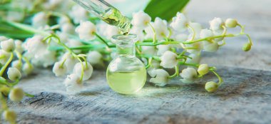 Vadideki zambak, küçük bir şişede gerekli yağ. Seçici odaklanma. Doğa.