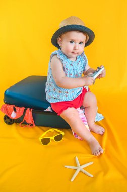 Bebek ve bavul, valiz taşıma konsepti. Denize tatile gidiyorum. Seçici odaklanma. Çocuk.