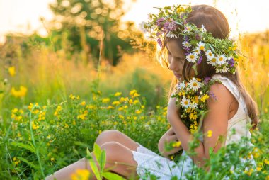 Yazın kır çiçekleriyle gezen kız çocuğu. Seçici odaklanma. Doğa.