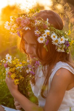 Yazın kır çiçekleriyle gezen kız çocuğu. Seçici odaklanma. Doğa.