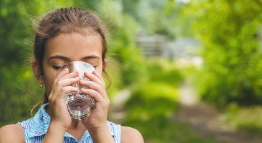 Çocuk kız bardaktan su içer. Seçici odaklanma. Çocuk.