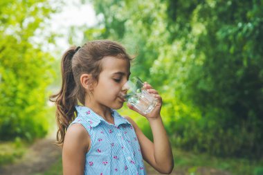 Çocuk kız bardaktan su içer. Seçici odaklanma. Çocuk.