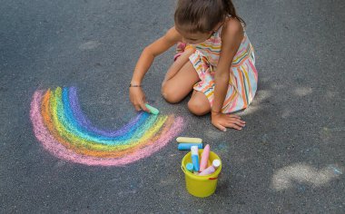 Çocuklar asfalta bir gökkuşağı çizerler. Seçici odaklanma. Çocuklar.