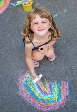 Çocuklar asfalta bir gökkuşağı çizerler. Seçici odaklanma. Çocuklar.