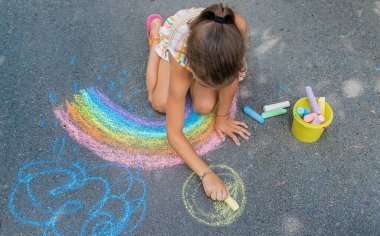 Çocuklar asfalta bir gökkuşağı çizerler. Seçici odaklanma. Çocuklar.