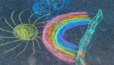 Çocuklar asfalta bir gökkuşağı çizerler. Seçici odaklanma. Çocuklar.