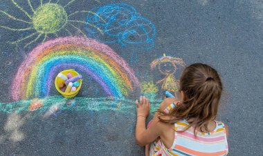 Çocuklar asfalta bir gökkuşağı çizerler. Seçici odaklanma. Çocuklar.