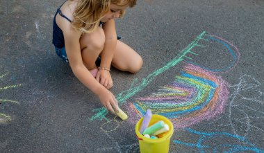 Çocuklar asfalta bir gökkuşağı çizerler. Seçici odaklanma. Çocuklar.