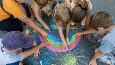 Çocuklar asfalta bir gökkuşağı çizerler. Seçici odaklanma. Çocuklar.