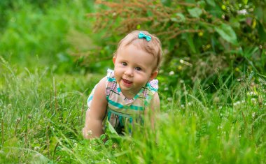 Bebek çimlerin üzerinde oturuyor. Seçici odaklanma. Doğa.