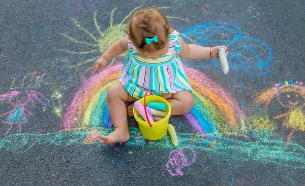 赤ん坊はチョークで歩道に虹を描く 選択的フォーカス — ストック写真
