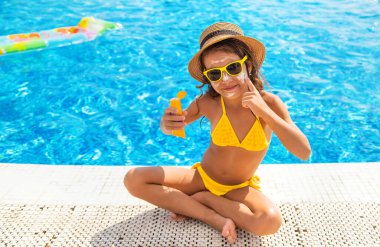 Çocuk yüzüne güneş kremi sürüyor. Seçici odaklanma. Çocuk.