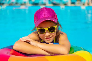 Çocuk havuzda bir daire içinde yüzüyor. Seçici odaklanma. Çocuk.