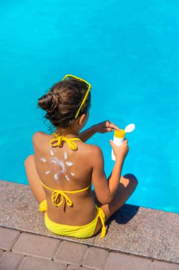 Çocuğun arkasında güneş kremi var. Seçici odaklanma. Çocuk.