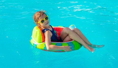 Çemberdeki bir çocuk havuzda yüzer. Seçici odaklanma. Çocuk.