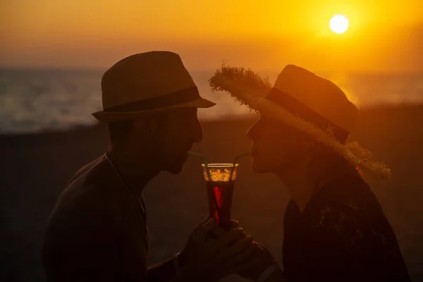 海に沈む夕日で男と女がカクテルを飲んでいる 選択的フォーカス — ストック写真