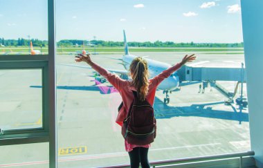 Havaalanındaki bir çocuk uçağa bakıyor. Seçici odaklanma. Çocuk.