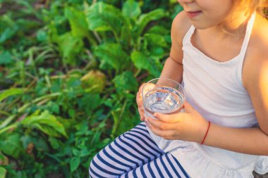 Dışarıda su içen bir çocuk. Seçici odaklanma. Çocuk.