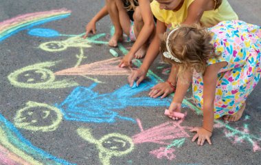 Çocuklar asfalta tebeşirle çizer. Seçici odaklanma. çocuk.