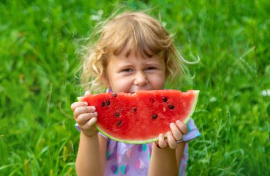 Çocuk yazın karpuz yiyor. Seçici odaklanma. Çocuk.