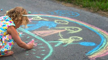 Çocuklar asfalta tebeşirle çizer. Seçici odaklanma. çocuk.