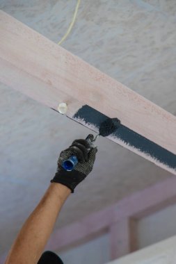 Ahşap kiriş boyayan bir adam. Seçici odaklanma. insanlar.