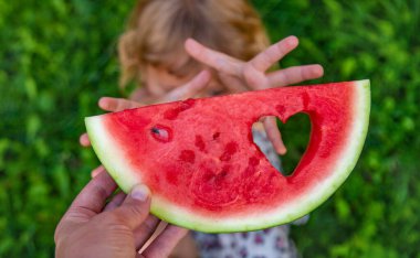 Parktaki bir çocuğun elinde bir karpuz parçası. Seçici odaklanma. yiyecek.
