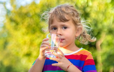 Bir çocuk bardaktan su içer. Seçici odaklanma. Çocuk.