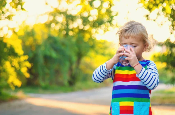 Bir çocuk bardaktan su içer. Seçici odaklanma. Çocuk.