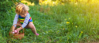 Bir çocuk çimenlerde paskalya yumurtası topluyor. Seçici odaklanma. Çocuk.