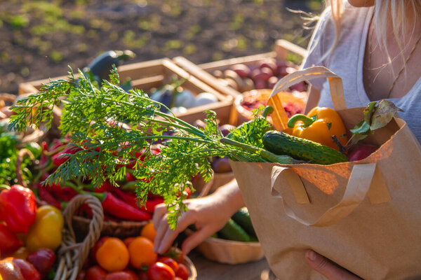 Женщина покупает фрукты и овощи на фермерском рынке. Выборочный фокус. Еда.