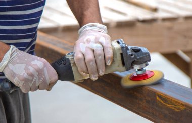 Bir adam metal bir direği işliyor. Seçici odaklanma. Doğa.