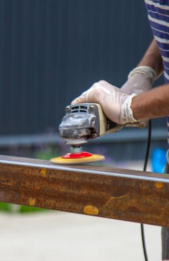 Bir adam metal bir direği işliyor. Seçici odaklanma. Doğa.