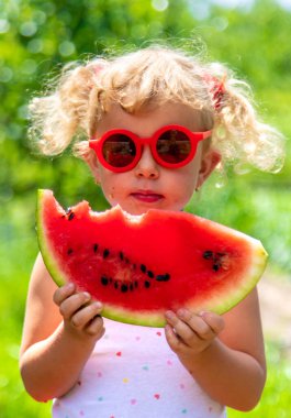 Bir çocuk parkta karpuz yiyor. Seçici odaklanma. Yiyecek..