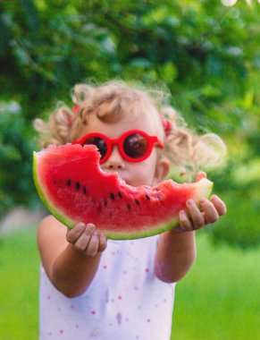 Bir çocuk parkta karpuz yiyor. Seçici odaklanma. Yiyecek..
