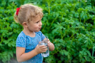 Bir çocuk bardaktan su içer. Seçici odaklanma. Çocuk.
