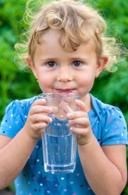 Bir çocuk bardaktan su içer. Seçici odaklanma. Çocuk.