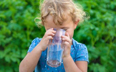 Bir çocuk bardaktan su içer. Seçici odaklanma. Çocuk.