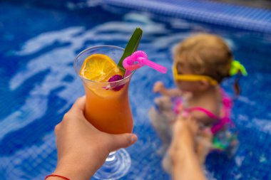 Havuzda bir kadın kokteyl içiyor. Seçici odaklanma. Seyahat.