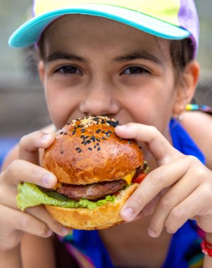Bir çocuk hamburger yer. Seçici odaklanma. Çocuk.