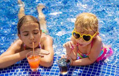 Çocuklar havuzda bir kokteyl içerler. Seçici odaklanma. Çocuklar.
