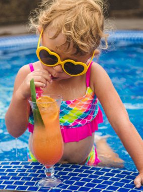 Havuzdaki bir çocuk kokteyl içiyor. Seçici odaklanma. Çocuk.