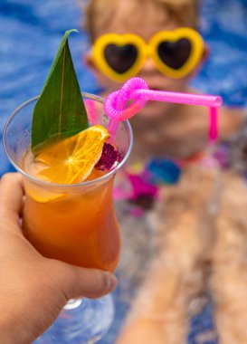 Havuzda bir kadın kokteyl içiyor. Seçici odaklanma. Seyahat.