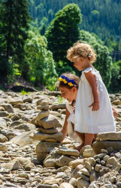 Çocuklar nehre taş atıyor. Seçici odaklanma. Çocuk.