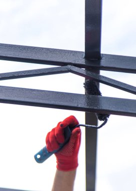 Metal direkleri boyayan bir adam. Seçici odaklanma. El..