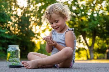 Çocuk elinde bir çekirge tutuyordu. Seçici odaklanma. Doğa.