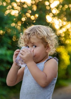 Bir çocuk bardaktan su içer. Seçici odaklanma. Çocuk.