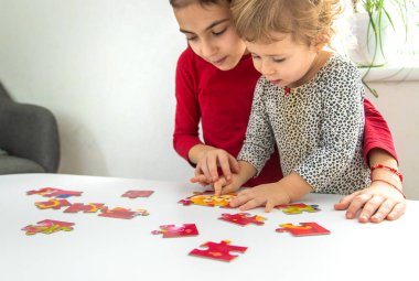 Çocuklar masaya bir yapboz koydular. Seçici odaklanma. Çocuk.