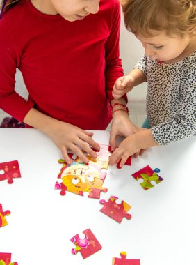 Çocuklar masaya bir yapboz koydular. Seçici odaklanma. Çocuk.